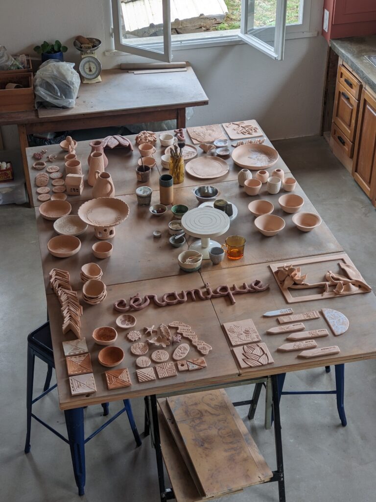 A propos vue intérieur atelier avec table remplie de céramiques