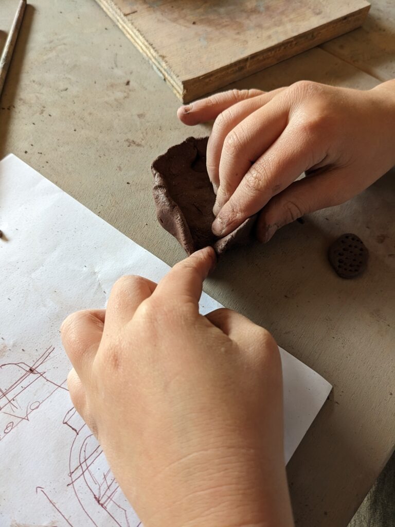 mains d'enfant qui modèle un bol avec Chloé Savarin